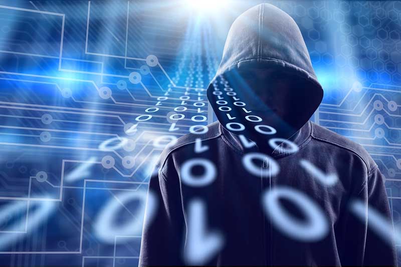 Hooded figure with binary code symbols against a digital background, symbolizing cybersecurity and hacker activities.