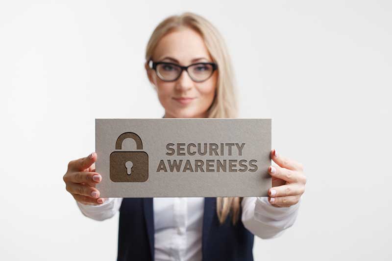 A woman holding a “Security Awareness” sign.